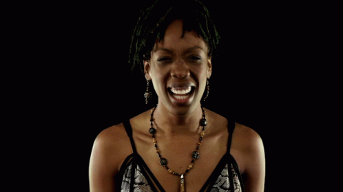 a young woman wearing a beaded necklace laughing