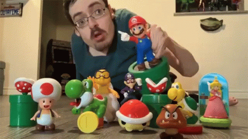 a man holding a toy in front of different figures on the floor