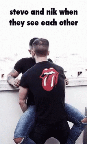 two people hug each other near a wall with the rolling stones