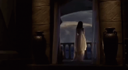 a woman in white dress standing in doorway