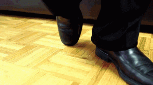 a close up of a person wearing a suit and tie standing on the floor