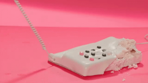 a video game remote sits partially eaten by a cord