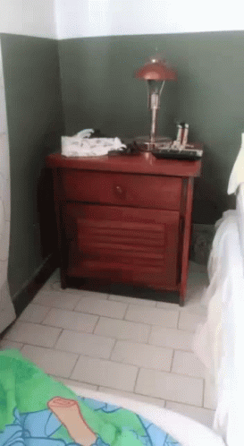 a blue chest of drawers in the corner of a bedroom