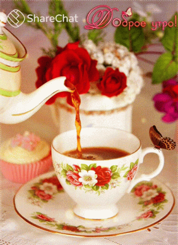 a teacup with flowers and tea is being poured into it