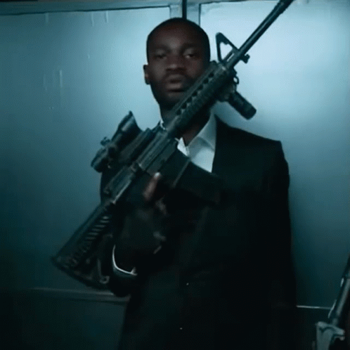a man holding a gun in a suit