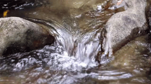 water flows over rocks in shallow waters