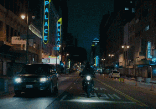 a person on a motorcycle driving down a busy city street
