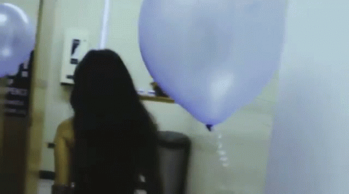 a person is blowing a balloon on the wall