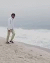 a guy on the beach is walking towards the water