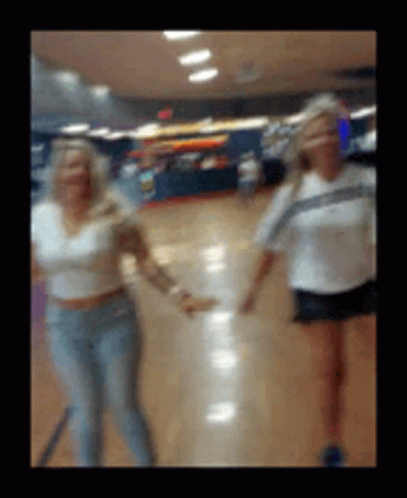 a blurred picture of two women walking through a building