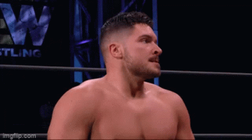 an intense looking man standing in a ring next to an wrestler