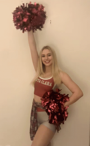 girl in a cheerleader outfit standing in a hallway