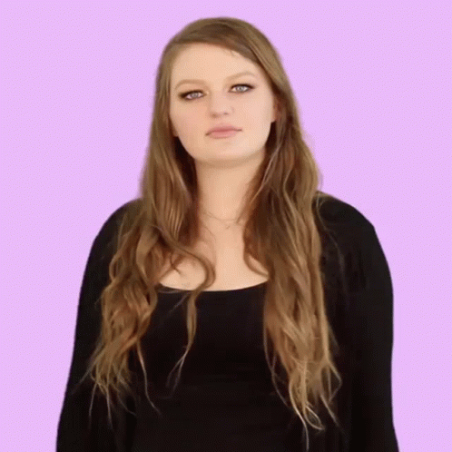 the female is posing for a po in front of a pink background