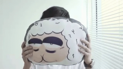 the woman holds a stuffed object with her eyes closed