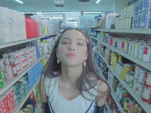 a woman wearing white shirt in the aisle of store