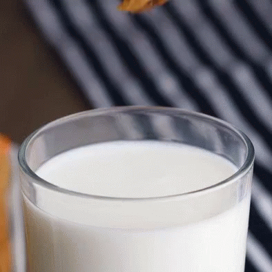 a glass of milk sits on a table
