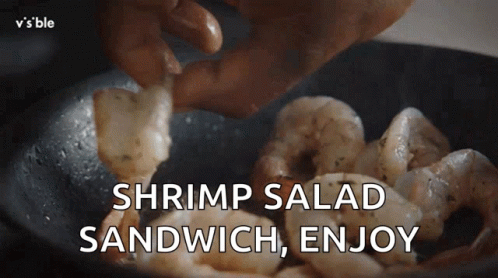 hand stirring food in black bowl on stove with text that reads shrimp salad sandwich, enjoy