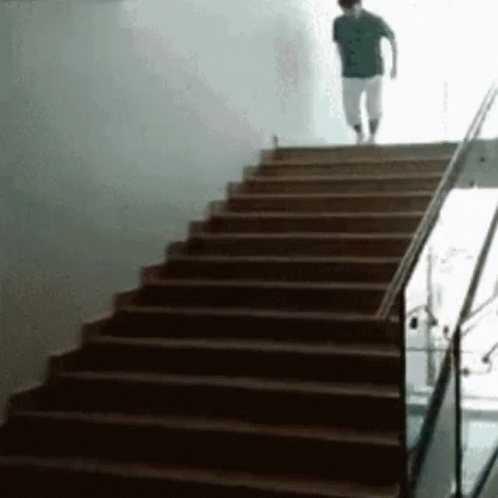 a man walking up stairs in front of a white wall