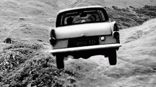 black and white image of old car on steep road
