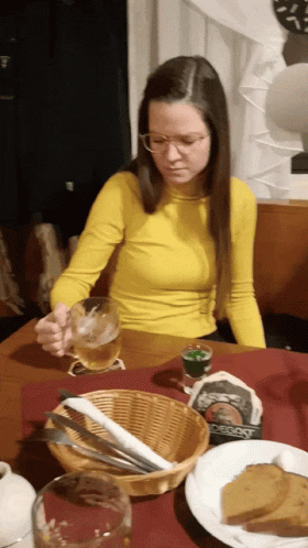 a woman sitting at a table in front of a plate with food