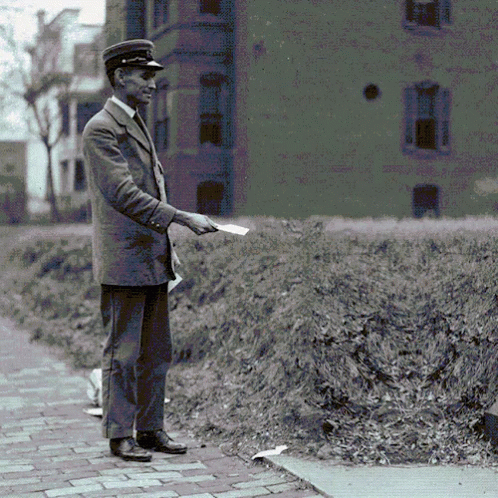 a man standing outside holding a piece of paper