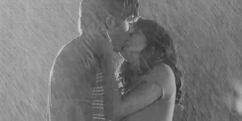 a woman kissing a man in the rain