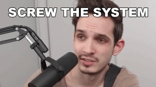 a guy speaking into a microphone, in front of a microphone that says screw the system