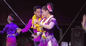 two people on stage dressed in fancy clothing