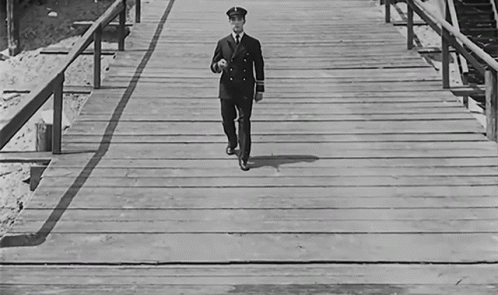 a man standing on a wooden pier walking on it