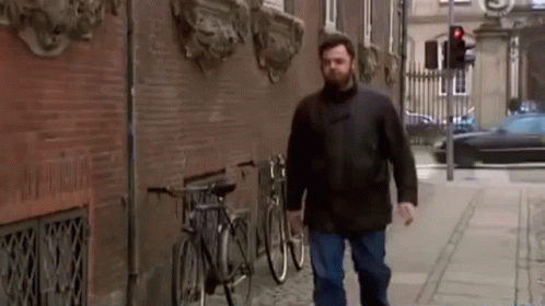 a man is walking down the street with a beard