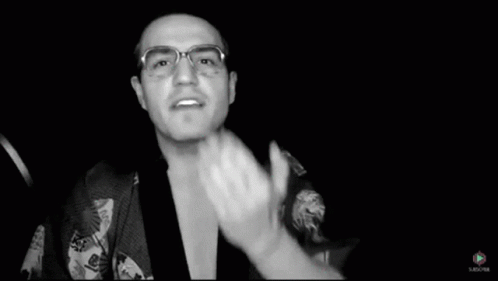the man is wearing glasses and is clapping