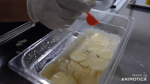 someone wearing gloves and white gloves is squeezing blue liquid from a plastic container