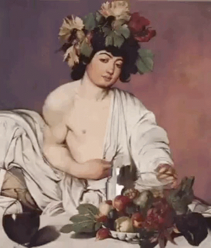 man holding flowers while seated on a blanket