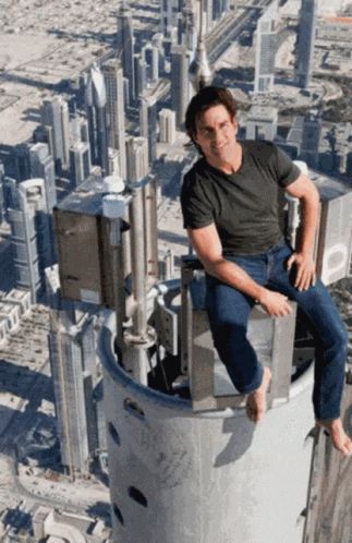 there is a man that is sitting on top of a tall tower