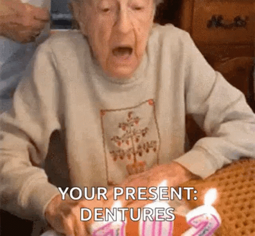 a woman with white skin holds a piece of cake with candles on it and has the text your present dentures