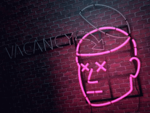 a neon sign in front of a brick wall