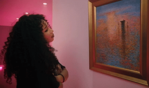 a woman looking at a painting by itself