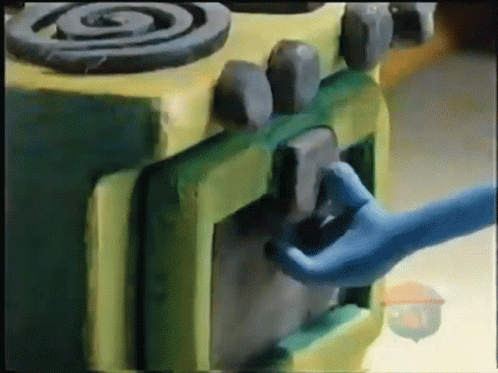 a hand touching the handle of a green toy stove
