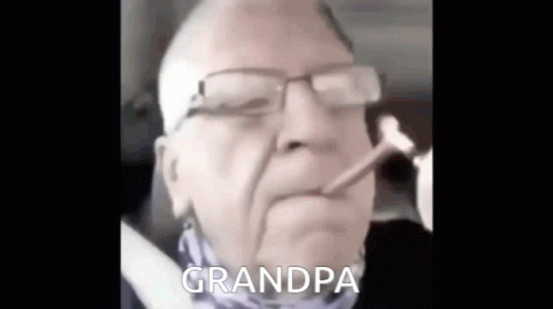 an old man wearing glasses is smoking and talking