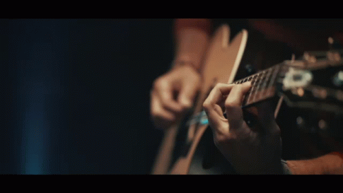 a person playing a guitar with one hand