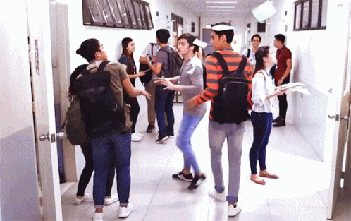a group of people in a hallway next to open doors