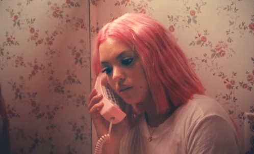 a girl with purple hair in a bathroom, with the phone