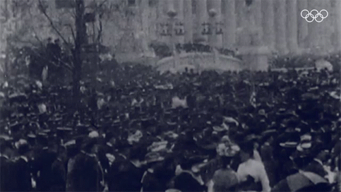 a large crowd of people standing on top of a street