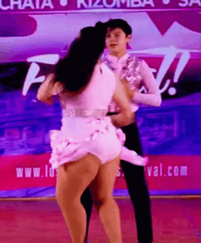 two people in costume are dancing on stage
