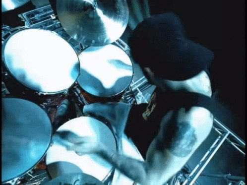 the drummer is playing drums near several other drums