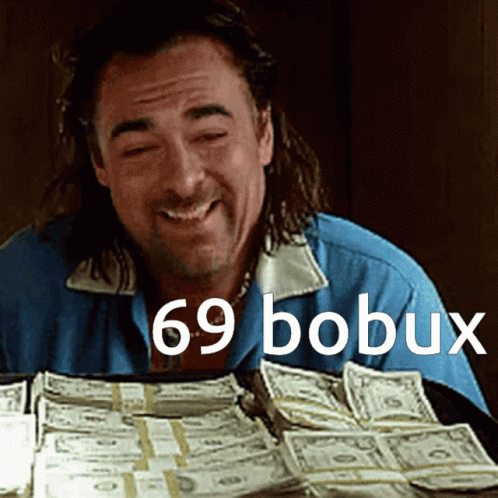 a man laughs while looking at many stacks of dollars