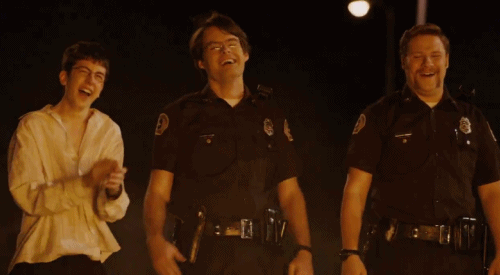 three young men in police uniforms are laughing