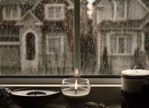 candles, an apple, and other decorations in front of a window
