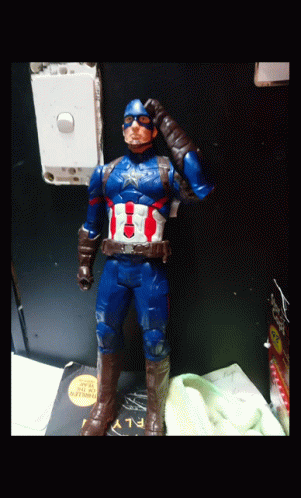 a toy soldier with a blue face and helmet in an office setting
