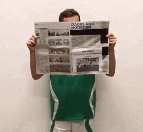 man standing up holding up a news paper